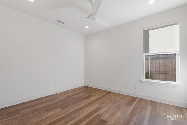 spare room with plenty of natural light, ceiling fan, and wood-type flooring