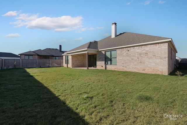 rear view of property with a yard