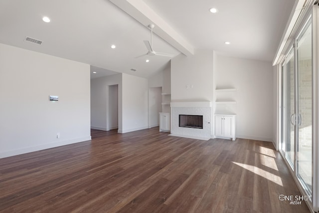 unfurnished living room with dark hardwood / wood-style flooring, lofted ceiling with beams, ceiling fan, and a tiled fireplace