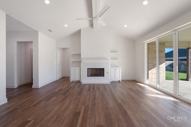 unfurnished living room featuring built in shelves, dark hardwood / wood-style floors, ceiling fan, and a healthy amount of sunlight