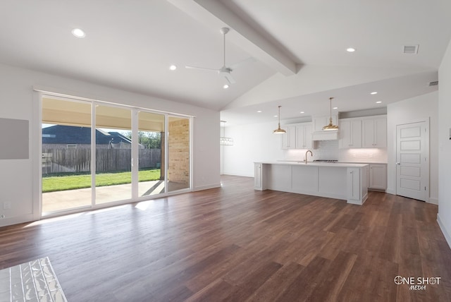 unfurnished living room featuring lofted ceiling with beams, ceiling fan, dark hardwood / wood-style flooring, and sink