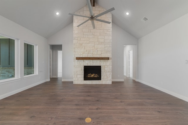 unfurnished living room with dark hardwood / wood-style flooring, ceiling fan, high vaulted ceiling, beamed ceiling, and a stone fireplace