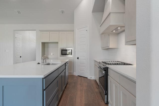 kitchen with sink, dark hardwood / wood-style flooring, a kitchen island with sink, appliances with stainless steel finishes, and custom exhaust hood