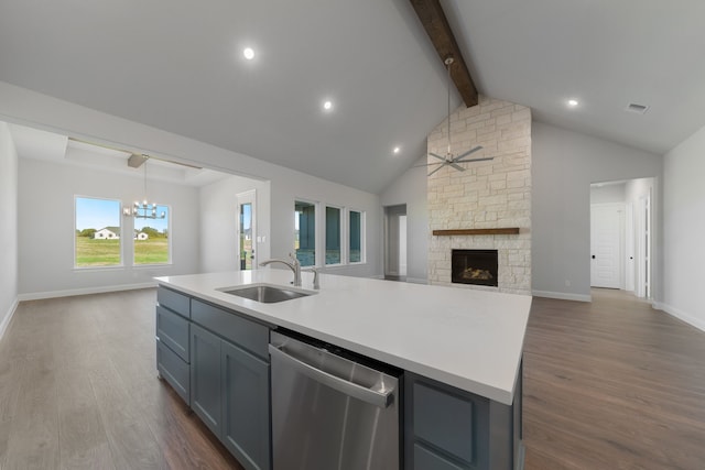 kitchen featuring dishwasher, a center island with sink, a stone fireplace, sink, and dark hardwood / wood-style floors