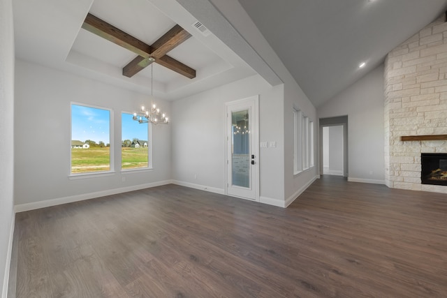 unfurnished living room with beam ceiling, a chandelier, a fireplace, and dark wood-type flooring