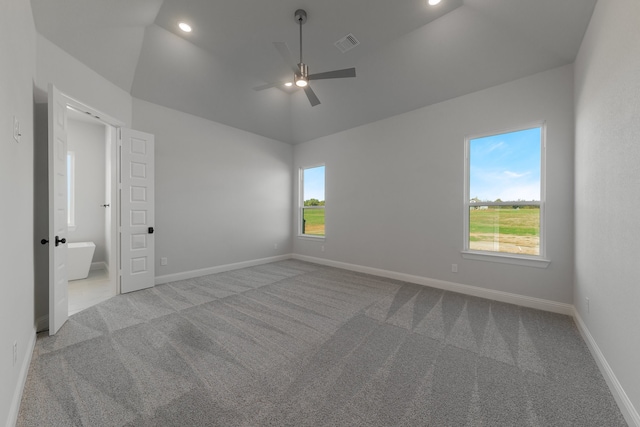 carpeted spare room featuring plenty of natural light, lofted ceiling, and ceiling fan