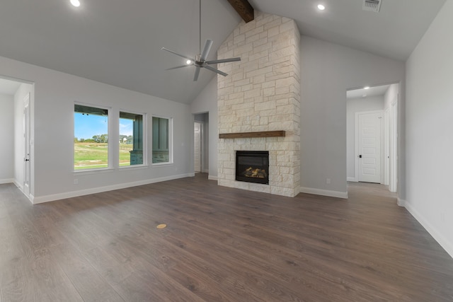 unfurnished living room with dark wood-type flooring, high vaulted ceiling, a stone fireplace, ceiling fan, and beamed ceiling