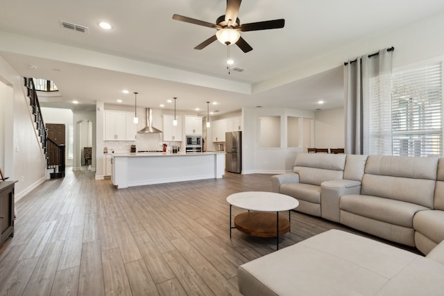 living room featuring ceiling fan and light hardwood / wood-style floors