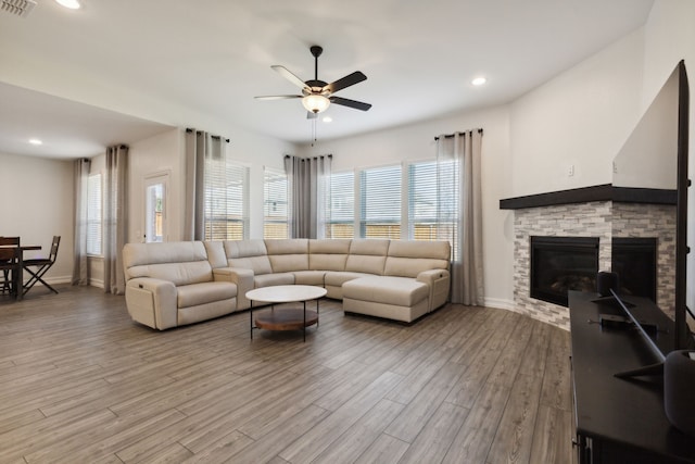 living room with ceiling fan, a fireplace, and wood-type flooring