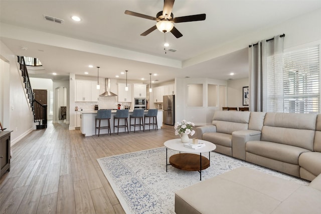 living room with ceiling fan and light hardwood / wood-style floors