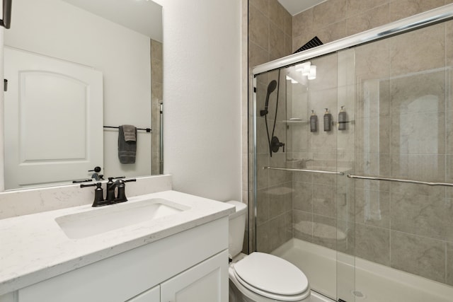 bathroom featuring vanity, an enclosed shower, and toilet