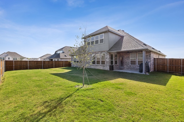 back of house with a yard and a patio