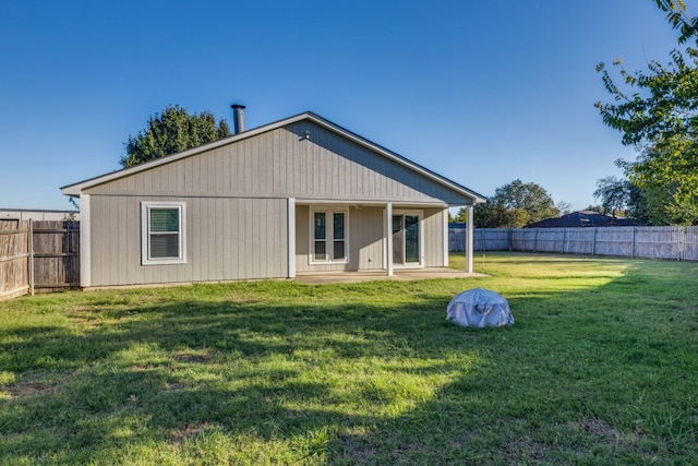 rear view of property with a patio and a lawn