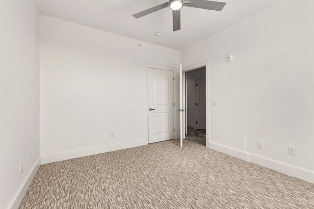 empty room with ceiling fan and light carpet