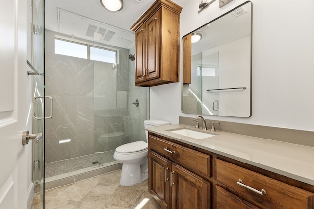 bathroom with toilet, vanity, and a shower with shower door