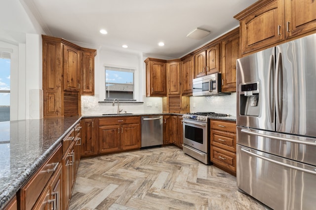 500 Waters Edge Dr Unit 239, Lake Dallas, TX 75065 - kitchen with appliances with stainless steel finishes, a sink, brown cabinets, recessed lighting, and dark stone counters