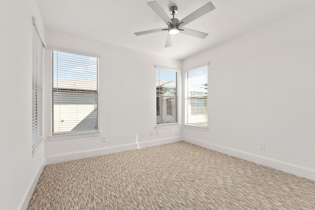 carpeted spare room with a wealth of natural light and ceiling fan