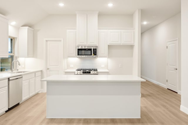 kitchen with a sink, tasteful backsplash, appliances with stainless steel finishes, and a kitchen island