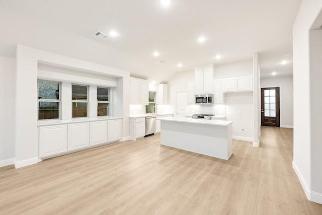 kitchen with light wood-style floors, baseboards, white cabinets, and stainless steel appliances