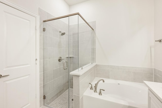 bathroom featuring a bath, vanity, and a stall shower