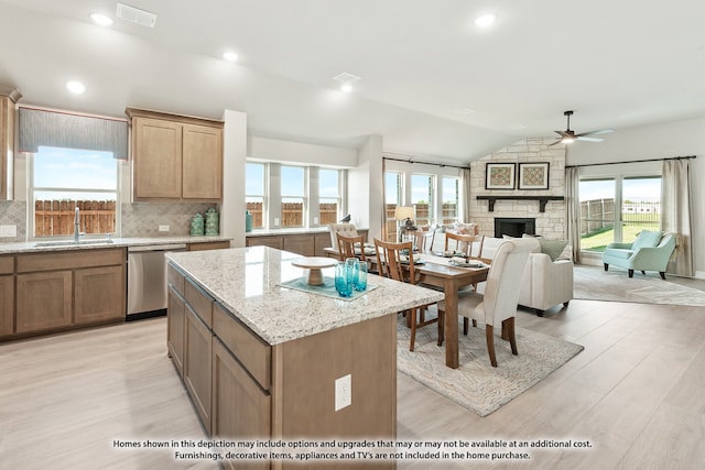 kitchen featuring a wealth of natural light, stainless steel dishwasher, and vaulted ceiling