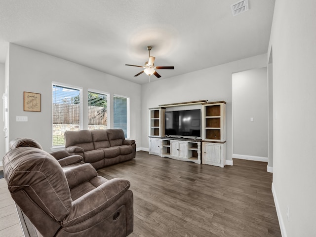 living room featuring ceiling fan and dark hardwood / wood-style floors