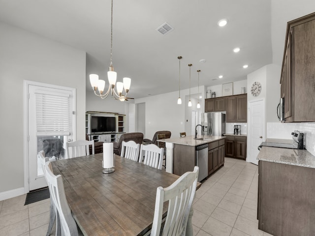 dining room with an inviting chandelier, sink, and light tile patterned floors