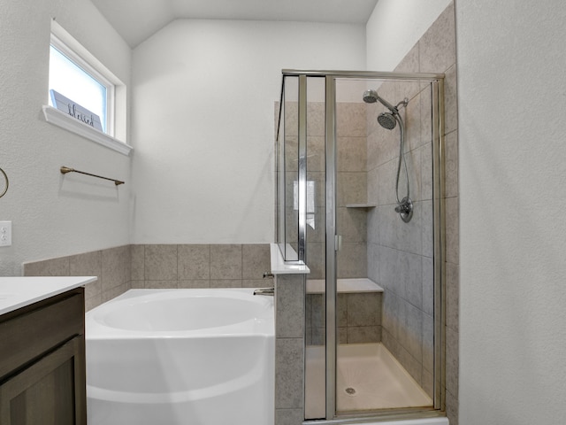 bathroom with vanity, lofted ceiling, and separate shower and tub