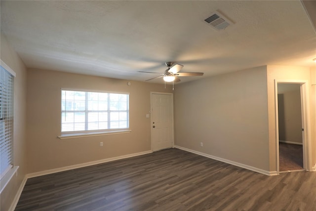 spare room with ceiling fan and dark wood-type flooring