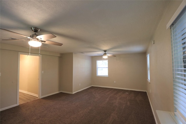 unfurnished room with dark colored carpet, a textured ceiling, and ceiling fan