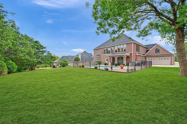 view of yard with a garage and a fenced in pool