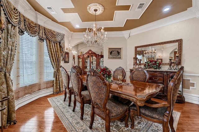 dining area featuring ornamental molding, hardwood / wood-style floors, and a chandelier