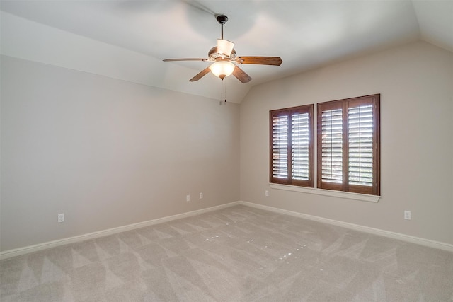 spare room featuring lofted ceiling, light colored carpet, and ceiling fan