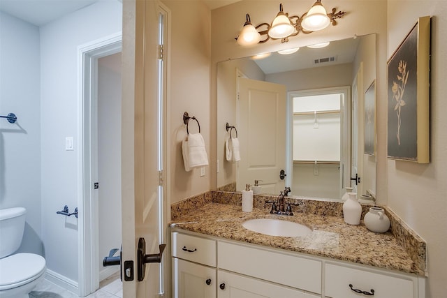 bathroom featuring tile patterned floors, vanity, and toilet