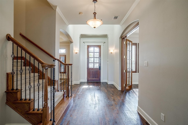 entrance foyer with dark hardwood / wood-style floors and crown molding