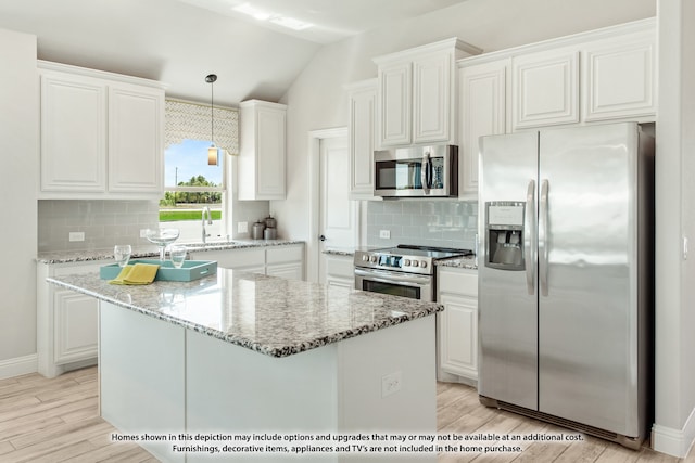 kitchen with white cabinetry, appliances with stainless steel finishes, vaulted ceiling, and light hardwood / wood-style flooring