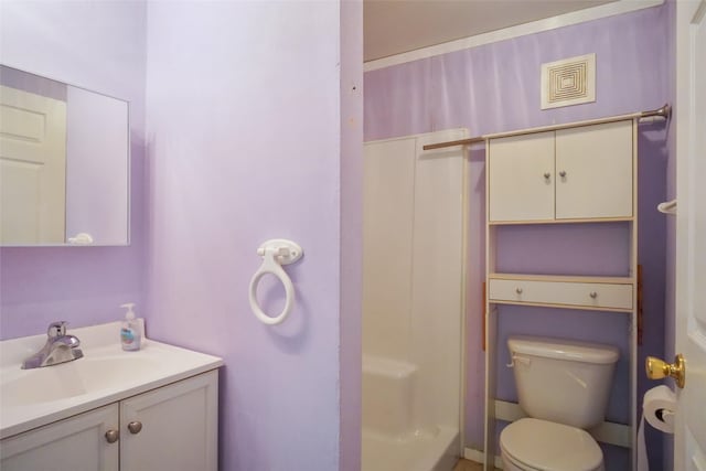 bathroom featuring walk in shower, vanity, and toilet