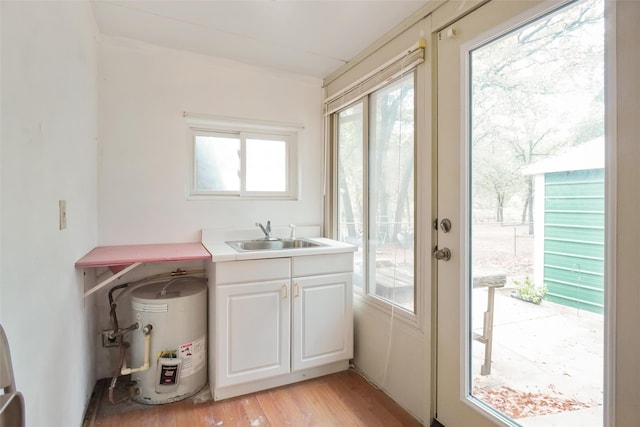 doorway featuring electric water heater, sink, and light hardwood / wood-style flooring