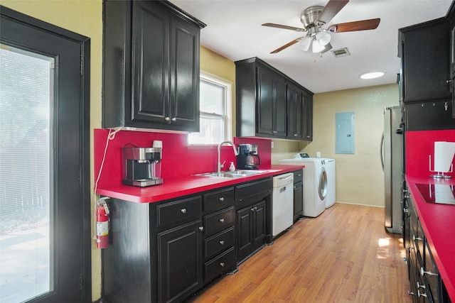 kitchen featuring light hardwood / wood-style floors, stainless steel refrigerator, electric panel, white dishwasher, and washing machine and clothes dryer