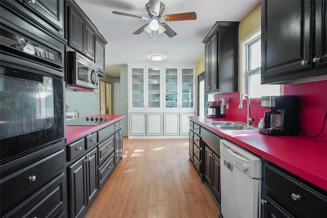 kitchen with light wood-type flooring, black appliances, sink, and ceiling fan