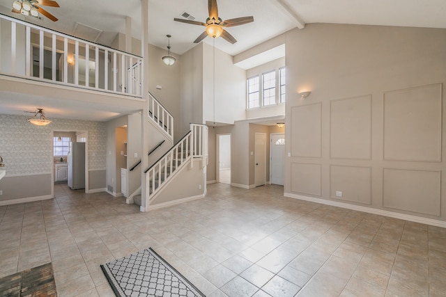 tiled entryway with ceiling fan and high vaulted ceiling