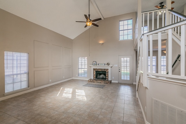 unfurnished living room with high vaulted ceiling, a healthy amount of sunlight, and ceiling fan