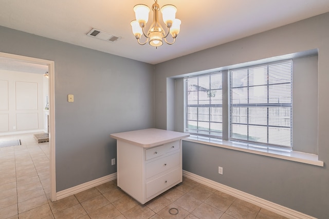 unfurnished office featuring a notable chandelier and light tile patterned floors