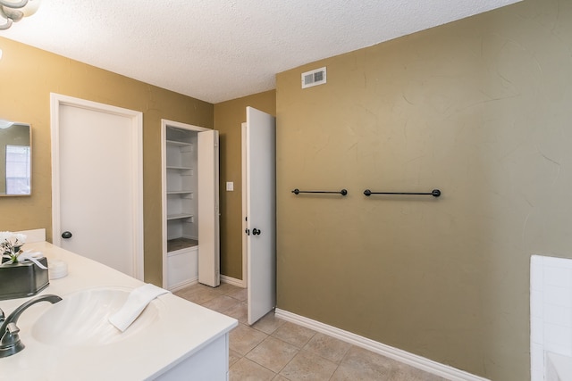 bathroom featuring vanity, a textured ceiling, and tile patterned floors