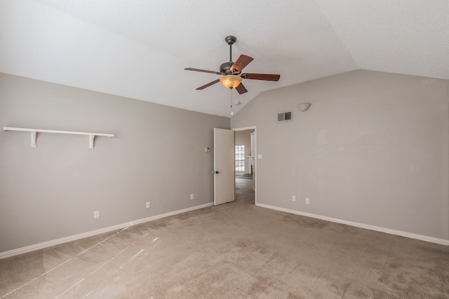 spare room with lofted ceiling, light colored carpet, and ceiling fan