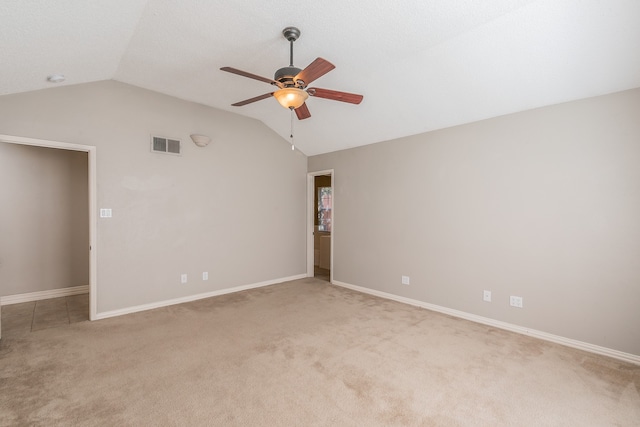 spare room with lofted ceiling, light colored carpet, and ceiling fan