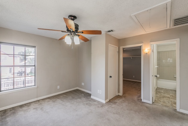 unfurnished bedroom featuring a textured ceiling, light carpet, and ceiling fan