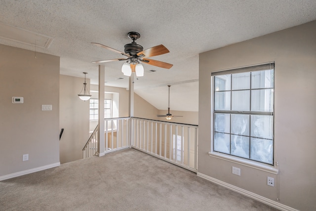 carpeted spare room featuring lofted ceiling, a textured ceiling, and ceiling fan