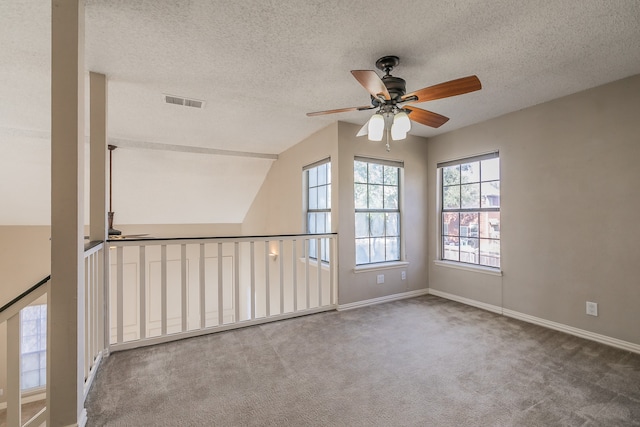 carpeted spare room featuring ceiling fan, a textured ceiling, and lofted ceiling