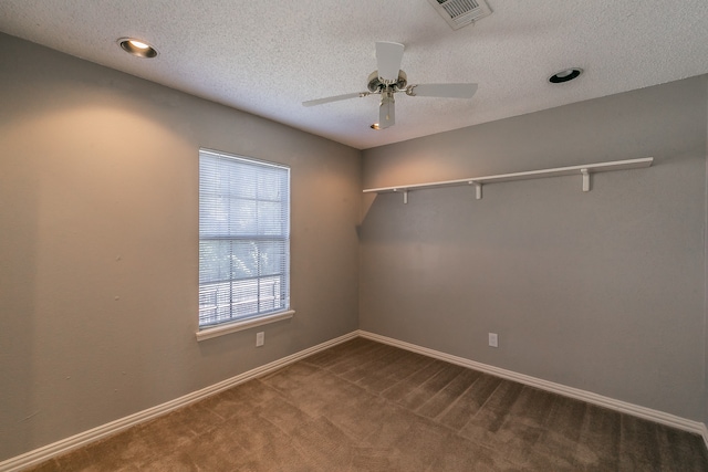 carpeted spare room featuring a textured ceiling and ceiling fan